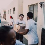 Group of volunteers handing out aid boxes to support community donations.
